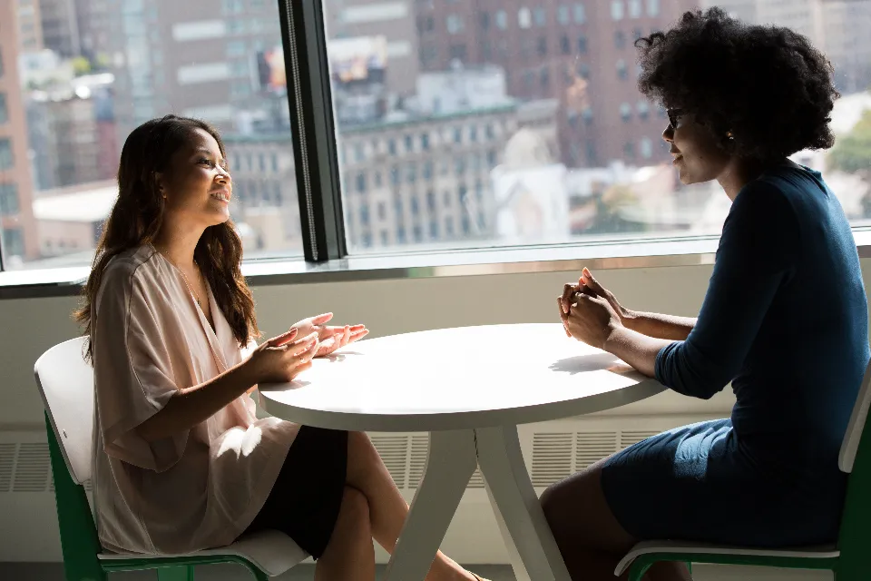 Two colleagues talking through a client's coverage at a window table