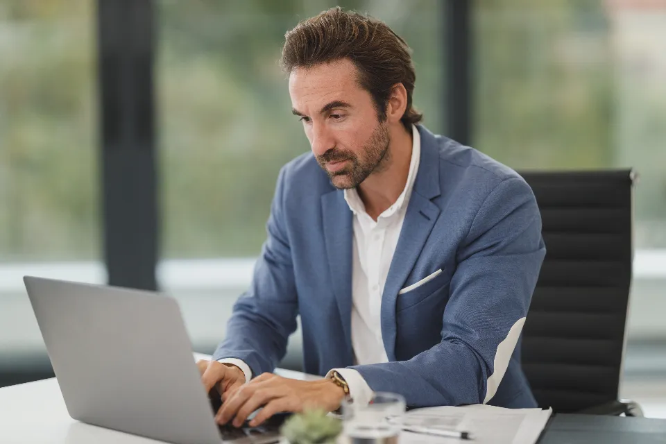 A man reading a plan comparison on his laptop