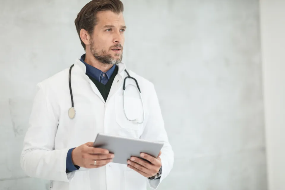 A doctor reviewing notes on a tablet