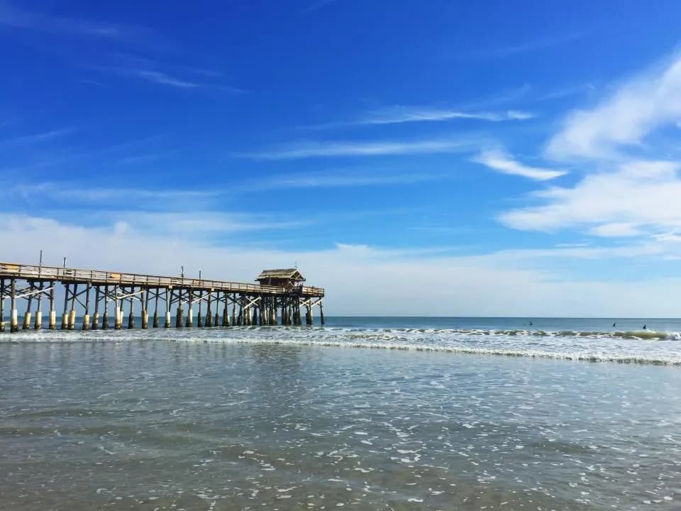 A fishing pier stretching into the ocean at sunrise